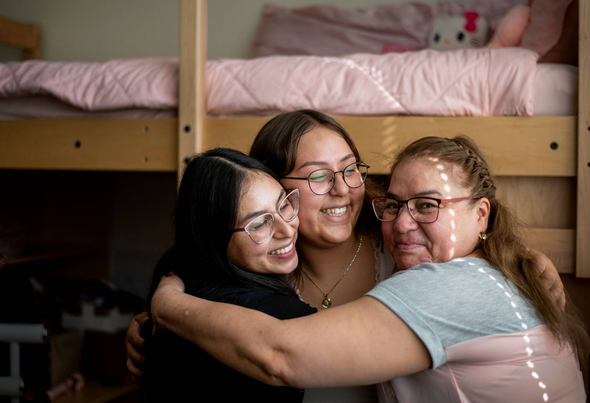 three people hugging in dorm